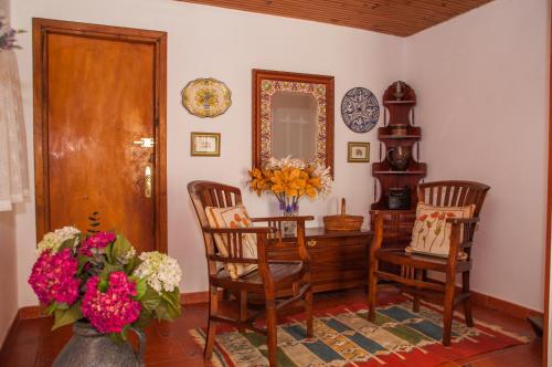 Zimmer mit einem Tisch, 2 Stühlen und einem Spiegel in der Unterkunft Miyares casa rural in Miyares