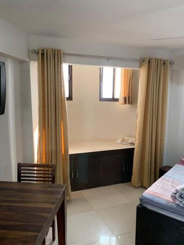 a bedroom with a bed and a desk and a table at Kamil’s Studio Apartment in Lucknow