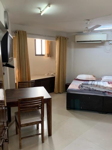 Habitación con cama, mesa y escritorio. en Kamil’s Studio Apartment en Lucknow