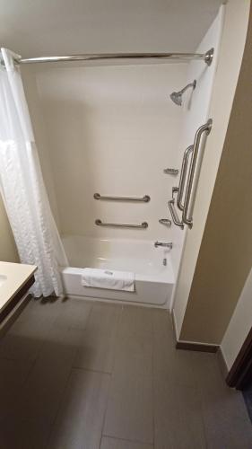 ein Bad mit einer Dusche und einer Badewanne in einem Zimmer in der Unterkunft Wingate by Wyndham Pittsburgh New Stanton in New Stanton