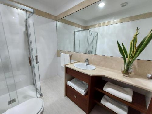 a bathroom with a sink and a shower at Neves by BCA Villas in São Gonçalo