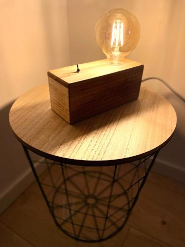 a table with a lamp on top of it at The Loft Factory 4 Chambres Vue Garonne + Jardin in Lormont
