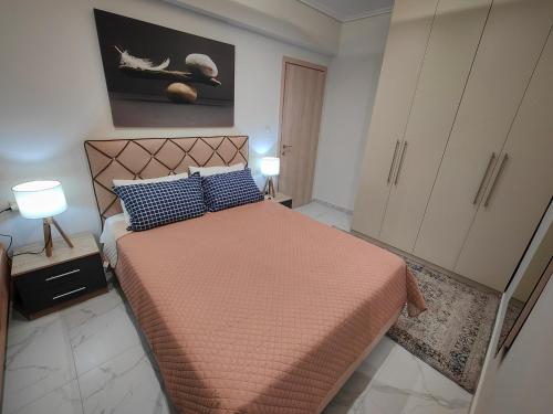 a bedroom with a bed with a orange bedspread and blue pillows at Cozy Sea View Apartment in Paralia in Paralia Katerinis