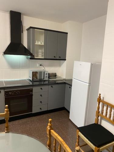 a kitchen with a table and a white refrigerator at Casa SanJuan in Baeza