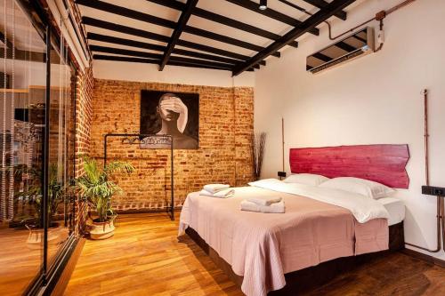 Origine Rentals Galata Tower A5 في إسطنبول: غرفة نوم بسرير كبير وجدار من الطوب