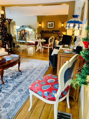 a living room with a christmas tree and a chair at Buttonwood Inn on Mount Surprise in North Conway