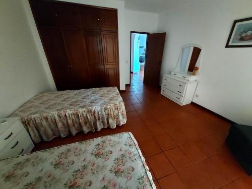 een kamer met 2 bedden en een tv. bij Albufeira INN - Casa dos Aveiros - Dolamar 4A T1 in Albufeira