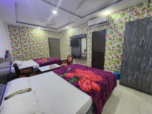 um quarto com duas camas e flores nas paredes em Golden Park Inn em Jarmundi