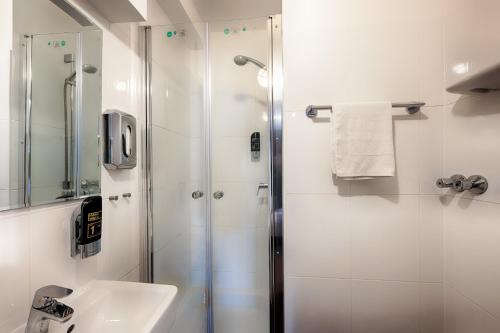 a bathroom with a shower and a sink at Hotel West in Hamburg