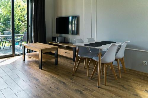 a dining room with a table and chairs and a television at Hortensja in Wilków