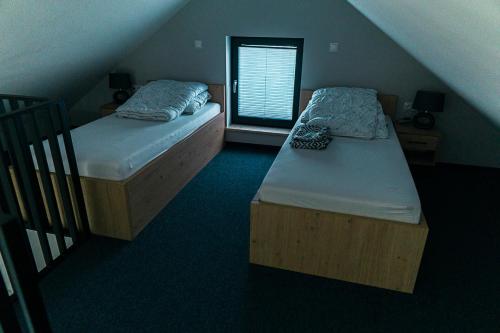 two twin beds in a room with a staircase at Hortensja in Wilków