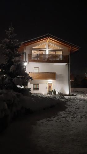 a house at night with a tree in front of it at Il giardino di Anna - Appartamento 1 in Fai della Paganella