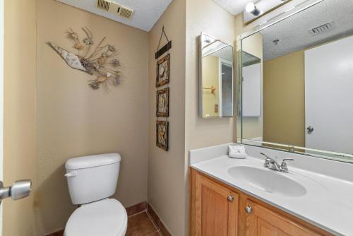 a bathroom with a sink and a toilet and a mirror at Perdido Sun 212 in Perdido Key