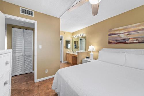 a bedroom with a white bed and a bathroom at Perdido Sun 212 in Perdido Key