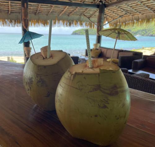 three vases with umbrellas sitting on a table at a beach at Tenuta Chatham Bay in Union Island