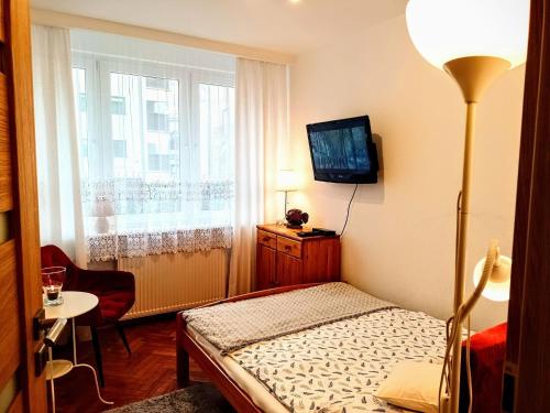 ein kleines Schlafzimmer mit einem Bett und einem Fenster in der Unterkunft Holiday flat, Swinoujscie in Świnoujście
