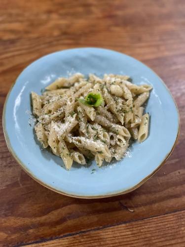 a plate of food with pasta on a wooden table at Tenuta Chatham Bay in Union Island