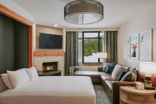 um quarto de hotel com uma cama e uma lareira em Summit Hotel at Big Sky Resort em Big Sky