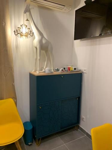 a giraffe statue sitting on top of a blue cabinet at LA DI MARIA in Narbonne
