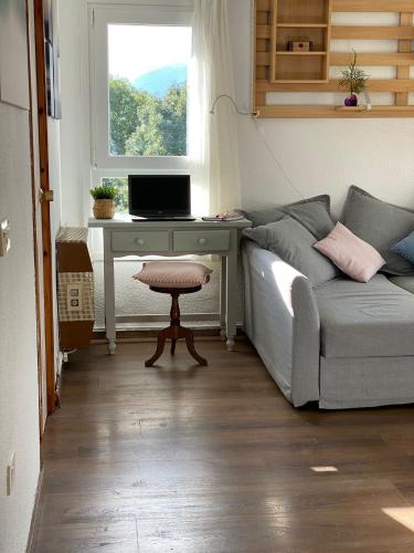 a living room with a couch and a desk with a laptop at Rincón de Cerler in Cerler