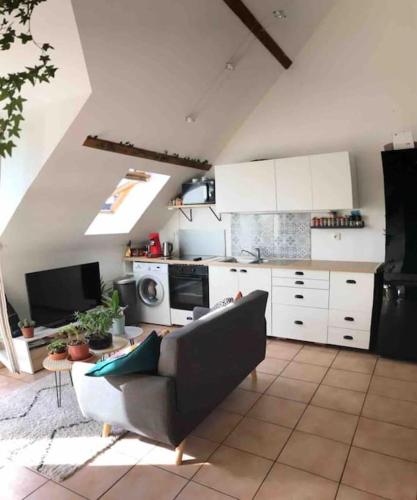 un salon avec un canapé et une cuisine dans l'établissement L'escale de Neauphle aux portes de Versailles, à Neauphle-le-Château