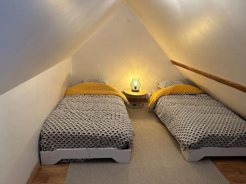 two twin beds in a attic bedroom with at L'escale de Neauphle aux portes de Versailles in Neauphle-le-Château