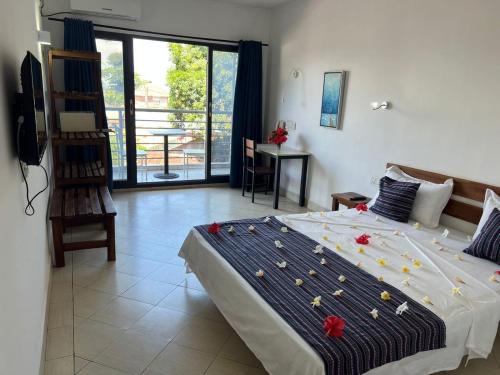 a bedroom with a large bed with flowers on it at Hôtel Ambatoloaka in Nosy Be