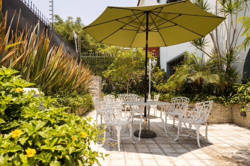 a table and chairs with a yellow umbrella at Casa Mateo in Guadalajara