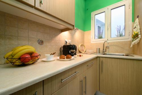 une cuisine avec un bol de fruits sur un comptoir dans l'établissement Apartment CALLAS in Corfu Town, à Corfou