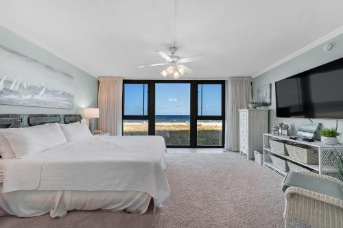 a bedroom with a white bed and a flat screen tv at Perdido Towers East 104 in Perdido Key