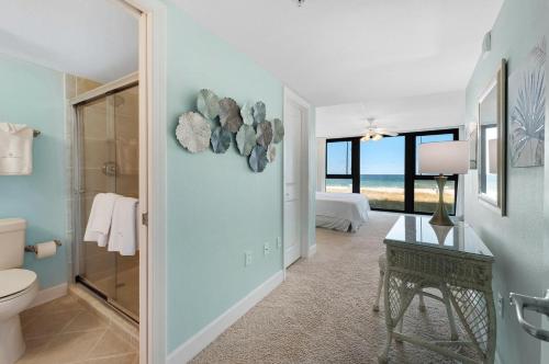 a bathroom with a toilet and a bedroom with the ocean at Perdido Towers East 104 in Perdido Key