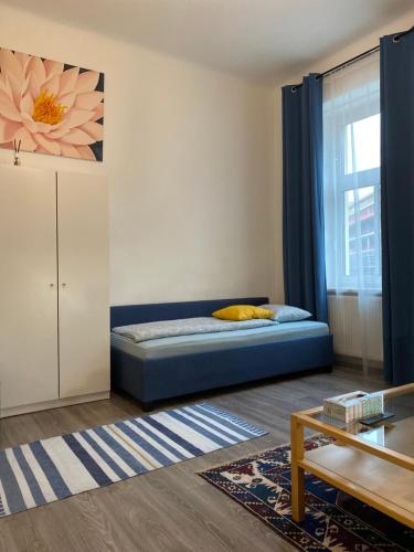 a bedroom with a blue bed and a window at Nice apartment between Schönbrunn and Karlsplatz in Vienna