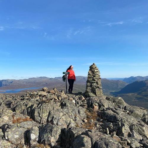 a woman standing on the top of a mountain at Hyggelig leilighet i sentrum in Hemsedal