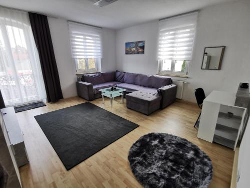 a living room with a purple couch and a table at Sehr Schönes 2 Zimmer Maisonnette Wohnung in Ansbach