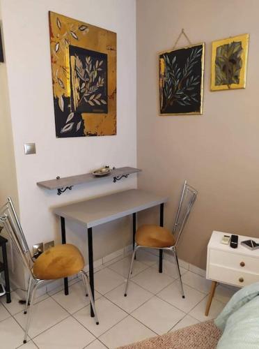 a room with a desk and two chairs in a room at Cozy studio, 1min from Kamara in Thessaloniki