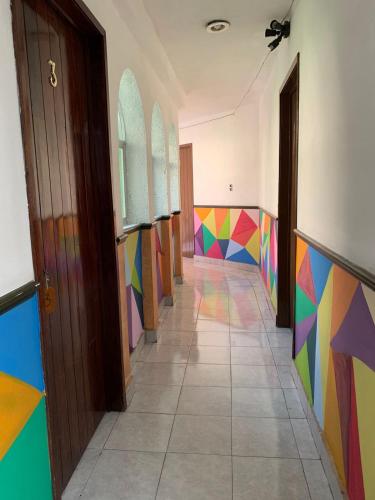 a hallway with colorful walls and a room with doors at Residencial Edzna in Campeche