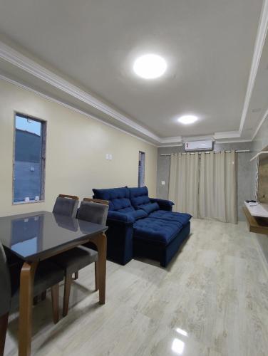 a living room with a blue couch and a table at Casa com Piscina Orla 500 Unamar Cabo Frio in Cabo Frio
