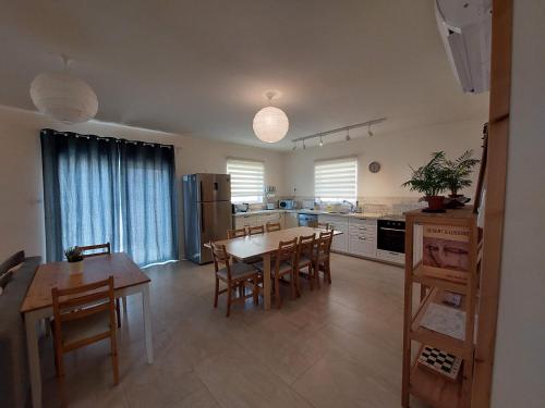 eine große Küche mit einem Tisch und Stühlen in der Unterkunft הבית ליד המצוק By The Cliff in Mitzpe Ramon