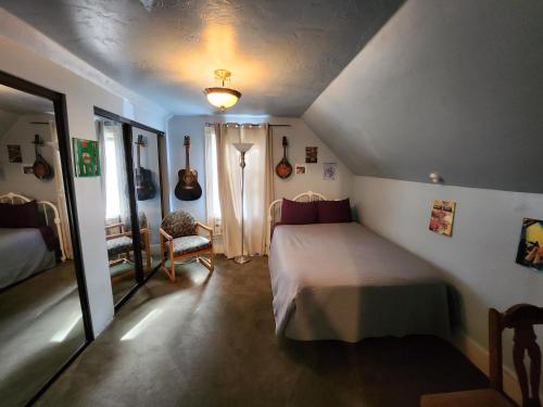 1 dormitorio en el ático con 1 cama y 1 silla en Eugene Lodge and International Hostel, en Eugene