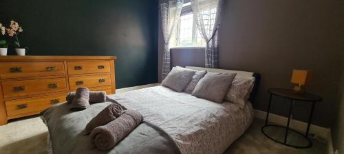 a bedroom with a bed and a dresser and a window at Spacious, 5 bed house for 9 in Chester in Chester