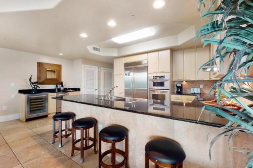 a kitchen with a large counter with bar stools at Caribe D216 in Orange Beach