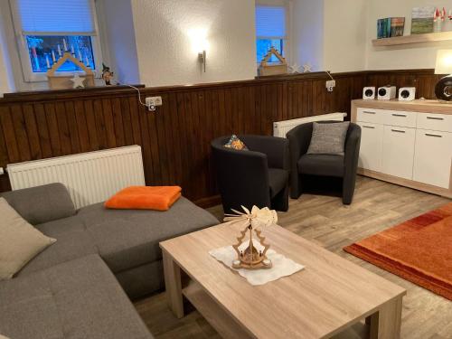 ein Wohnzimmer mit einem Sofa und einem Tisch in der Unterkunft Ferienhaus Tooren in Kurort Altenberg