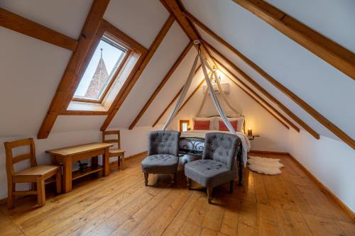 a attic room with a bed and two chairs at Boutique Hotel von Graf in Sighişoara