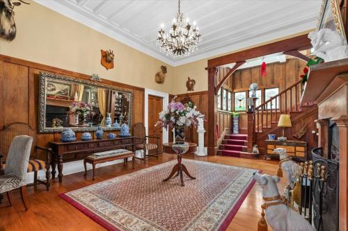 una sala de estar con paneles de madera y una lámpara de araña. en Ashcott Homestead Bed & Breakfast, en Takapau