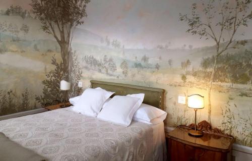 sypialnia z łóżkiem z obrazem na ścianie w obiekcie PACA casa rural. Arts and Landscape in Asturias w mieście Gijón