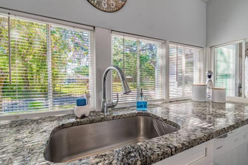 a kitchen with a sink and two windows at Enchanting & Welcoming 2 Bedroom Apartment-POLK #1 in New Port Richey