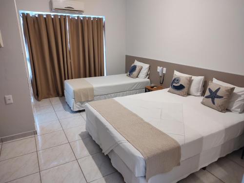 een hotelkamer met 2 bedden en een raam bij Hotel Guarda Mor in São Sebastião