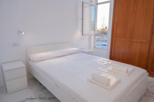 biała sypialnia z łóżkiem z 2 ręcznikami w obiekcie Apartamento Jogi Playa del inglés w mieście San Bartolomé