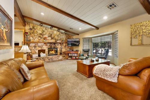 a living room with leather furniture and a stone fireplace at 2012-Moose Manor home in Big Bear Lake
