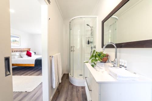 a bathroom with a shower and a sink with a mirror at River View Collingwood in Collingwood